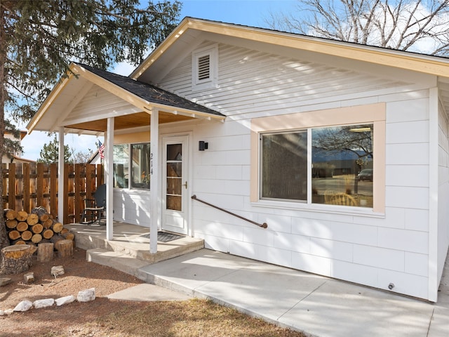 view of front of house featuring fence and roof with shingles