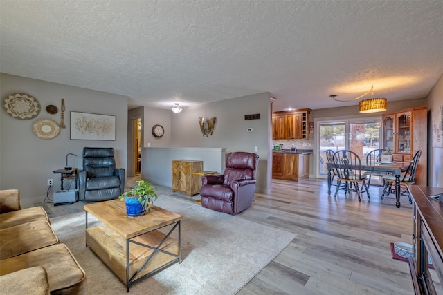 living area with a textured ceiling and light wood-style floors