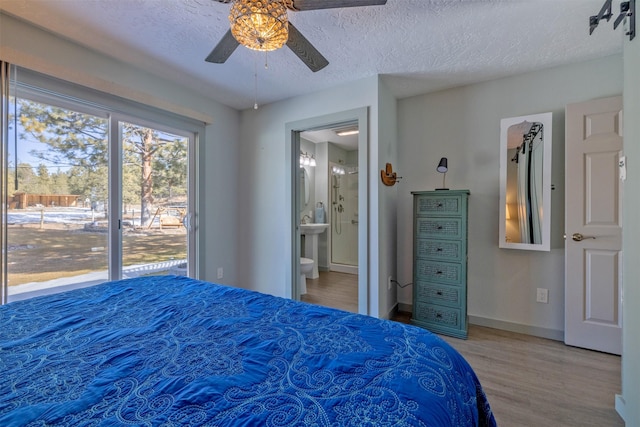 bedroom featuring ensuite bathroom, a textured ceiling, wood finished floors, a ceiling fan, and baseboards