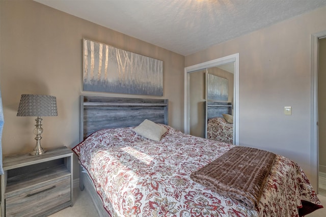 bedroom with a textured ceiling, a closet, and carpet flooring