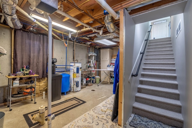 unfinished basement with stairs, visible vents, and electric water heater