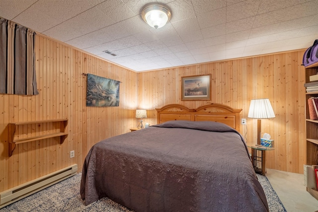 carpeted bedroom featuring visible vents and a baseboard heating unit