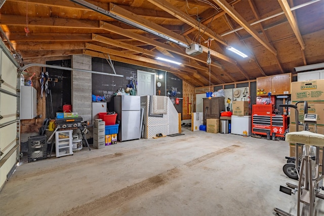 garage with a garage door opener and freestanding refrigerator