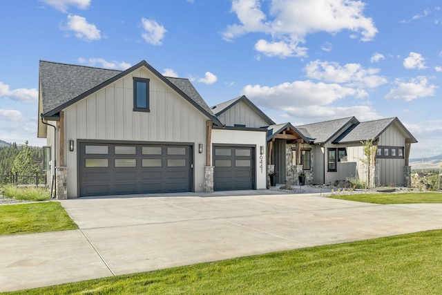 modern inspired farmhouse featuring a garage, driveway, board and batten siding, and roof with shingles