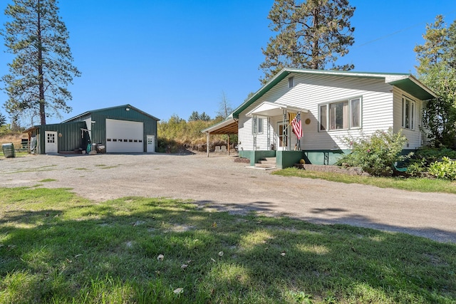 view of home's exterior with a garage, driveway, a lawn, and an outdoor structure