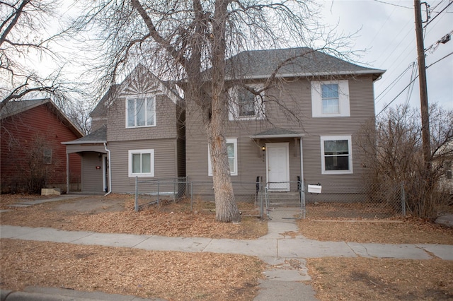 view of front of house with a fenced front yard, a gate, and roof with shingles