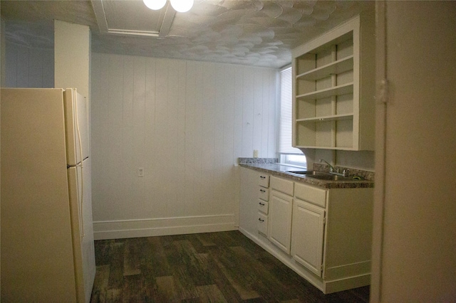 kitchen with dark wood-style flooring, open shelves, dark countertops, freestanding refrigerator, and a sink