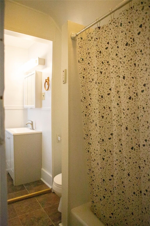 bathroom featuring toilet, tile patterned floors, shower / tub combo with curtain, and vanity