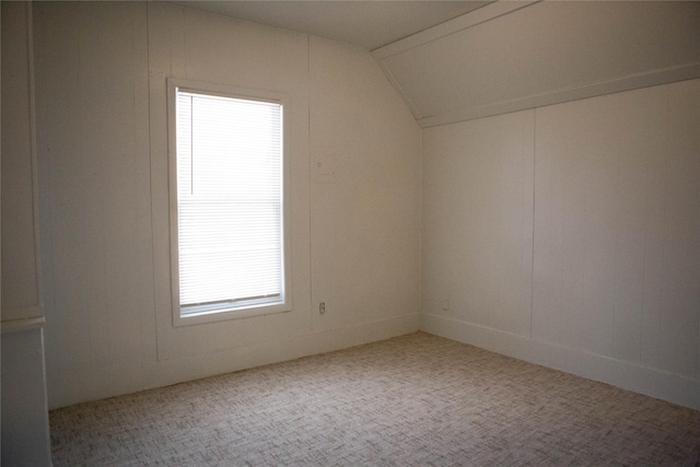 bonus room with lofted ceiling and carpet flooring