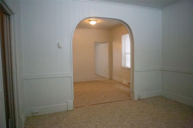 hall featuring arched walkways, visible vents, and carpet