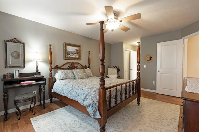 bedroom with ceiling fan, baseboards, and wood finished floors