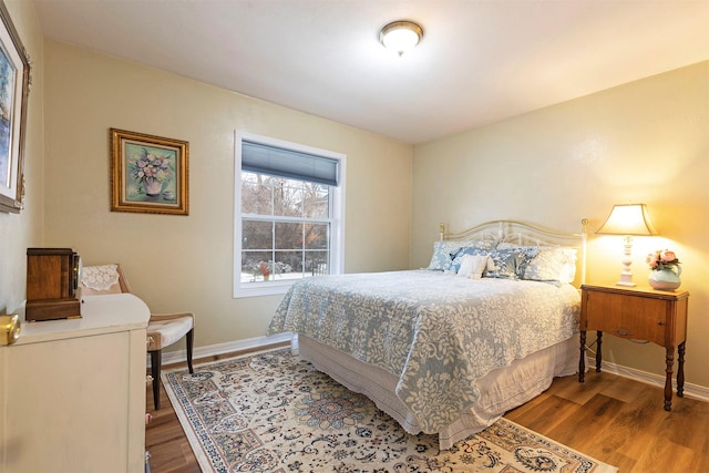 bedroom with baseboards and wood finished floors