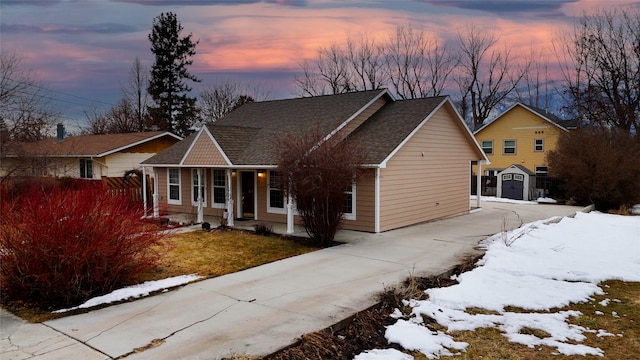 view of front of house with a storage shed, roof with shingles, an outbuilding, fence, and a porch