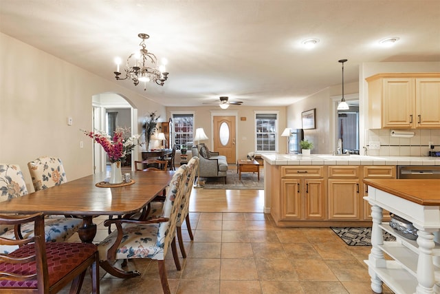 dining room featuring arched walkways and ceiling fan with notable chandelier