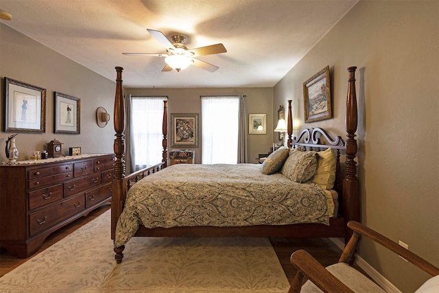 bedroom featuring ceiling fan, baseboards, and dark wood-type flooring