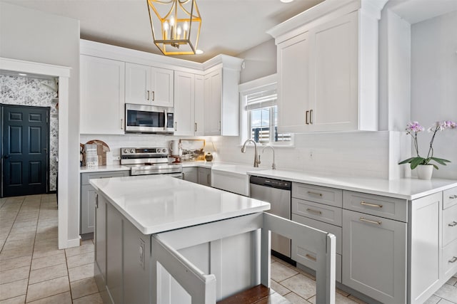 kitchen with appliances with stainless steel finishes, light countertops, backsplash, and light tile patterned flooring