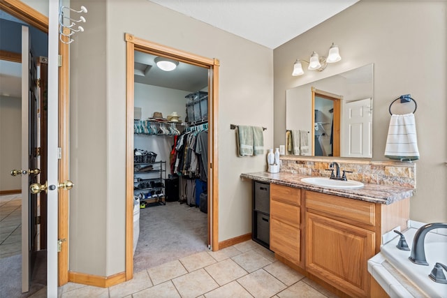 5331 Fiddler Ct, Florence, MT 59833 - bathroom with tile patterned floors, a spacious closet, vanity, baseboards, and a tub to relax in
