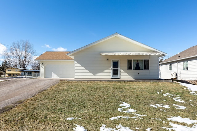 ranch-style home with driveway, an attached garage, and a front yard