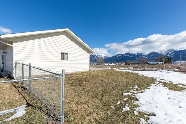 view of side of property with fence and a mountain view