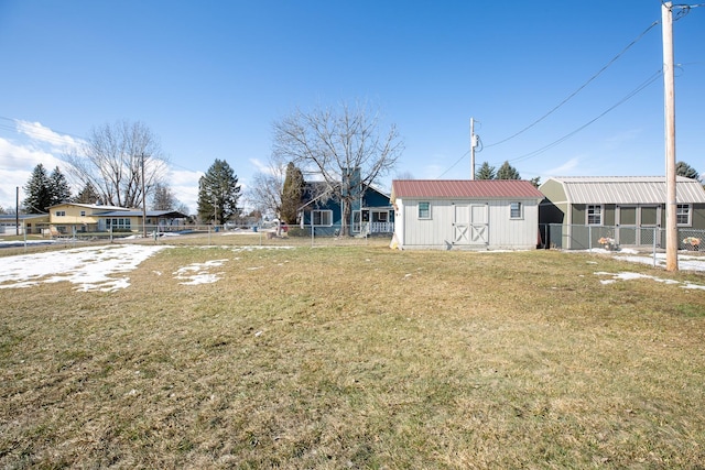 view of yard featuring an outbuilding, fence, and a storage shed