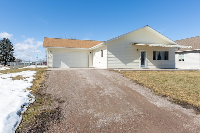 single story home featuring a front lawn, driveway, and an attached garage