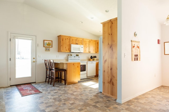 kitchen with a breakfast bar, lofted ceiling, light countertops, white appliances, and a peninsula