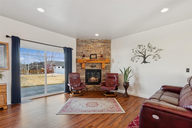 living area featuring a fireplace, baseboards, wood finished floors, and recessed lighting