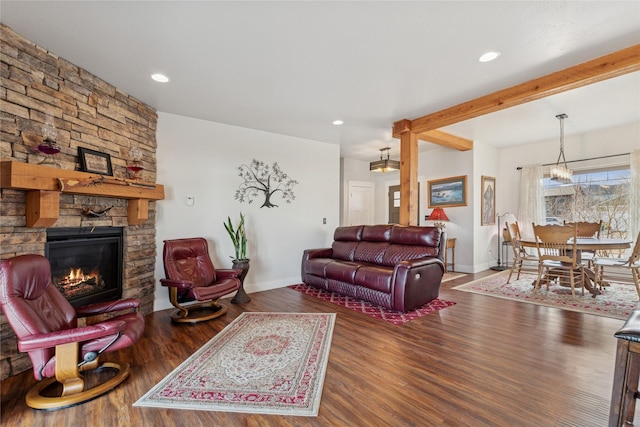 living room with recessed lighting, a stone fireplace, baseboards, and wood finished floors