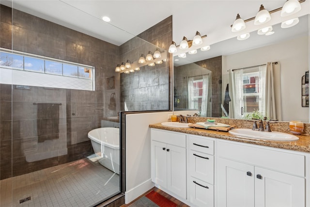 full bathroom with a soaking tub, plenty of natural light, and a sink