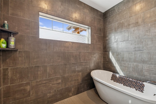 bathroom with a freestanding bath and tile walls