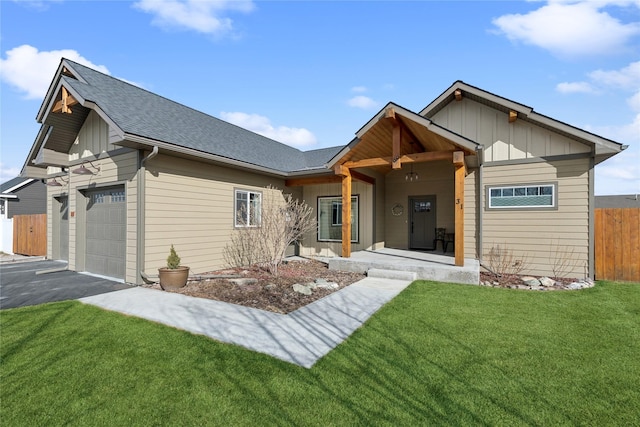 view of front facade featuring driveway, an attached garage, fence, board and batten siding, and a front yard