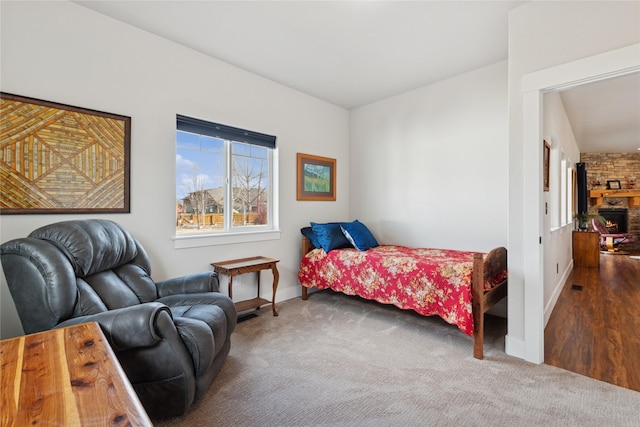 carpeted bedroom featuring visible vents, a fireplace, and baseboards