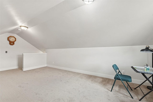 unfurnished office featuring lofted ceiling, baseboards, and light colored carpet