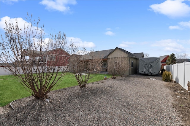 view of front of home featuring driveway, a front lawn, and fence