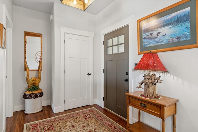 foyer with baseboards and wood finished floors