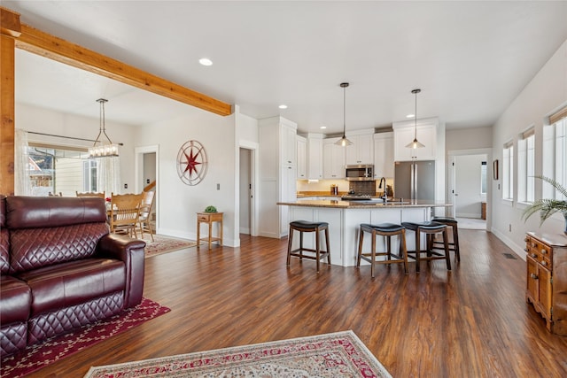 living area featuring dark wood-style flooring, plenty of natural light, and baseboards