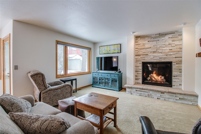 carpeted living area with a stone fireplace and baseboards