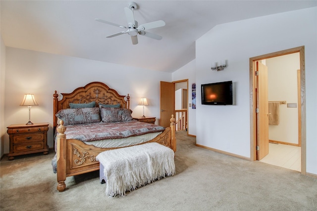 carpeted bedroom featuring lofted ceiling, ceiling fan, baseboards, and ensuite bathroom