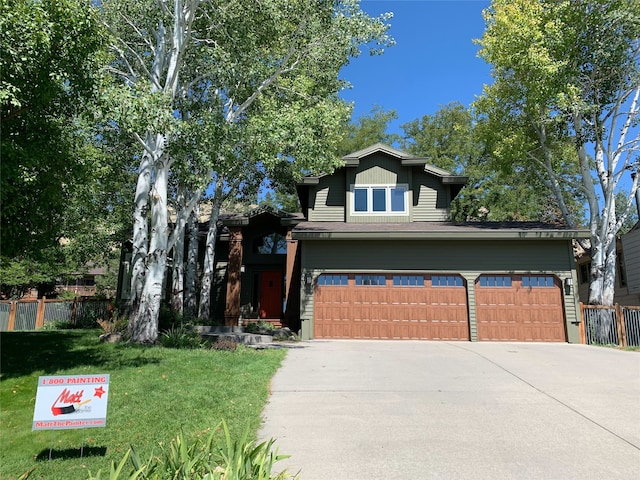 view of front of home featuring driveway, an attached garage, fence, and a front yard