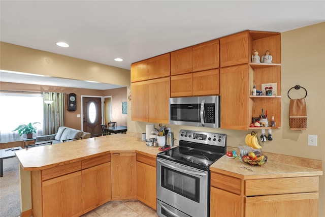 kitchen featuring stainless steel appliances, a peninsula, open floor plan, light countertops, and open shelves