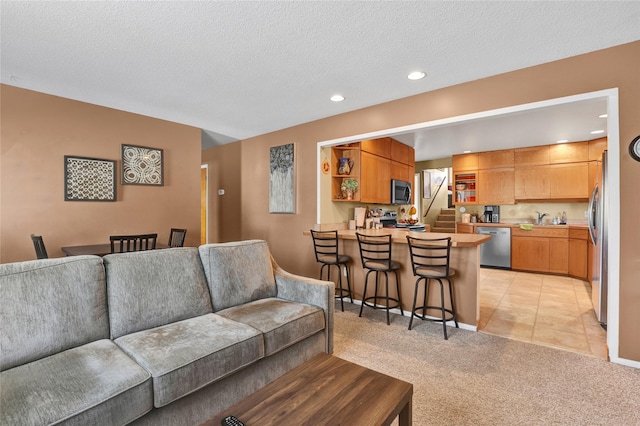 living area featuring light tile patterned floors, a textured ceiling, stairway, light colored carpet, and recessed lighting
