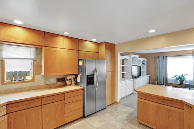 kitchen with plenty of natural light, stainless steel fridge, and light countertops