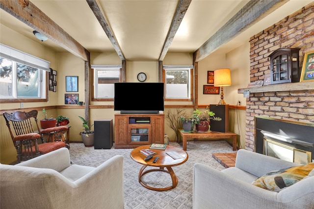 carpeted living area featuring a wealth of natural light, a brick fireplace, beam ceiling, and a wainscoted wall