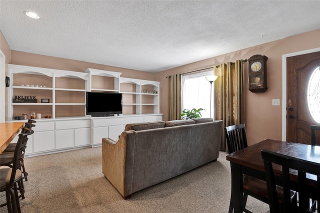 living area with light carpet and a textured ceiling