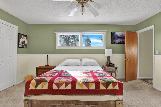 bedroom with a ceiling fan, carpet, and a textured ceiling