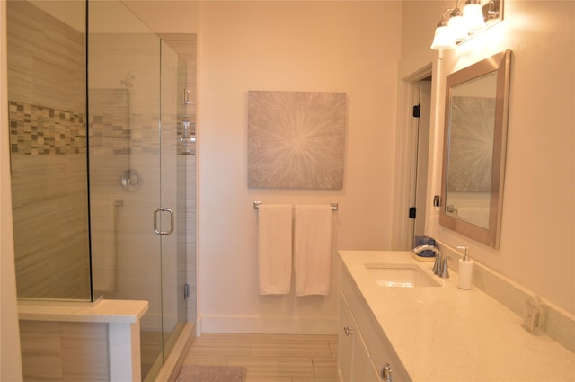 bathroom with a shower stall, vanity, and baseboards