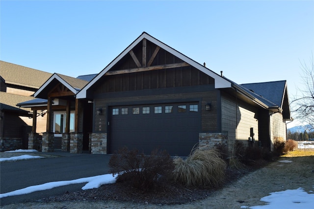 craftsman-style house featuring stone siding, board and batten siding, and an attached garage