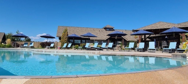 community pool featuring fence and a patio