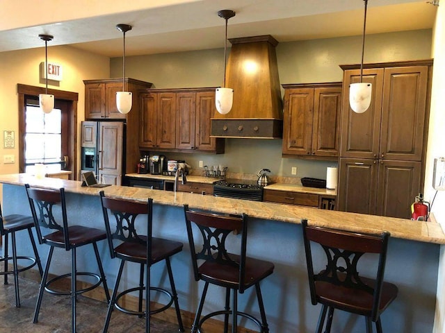 kitchen with light stone counters, hanging light fixtures, electric range oven, paneled built in refrigerator, and premium range hood