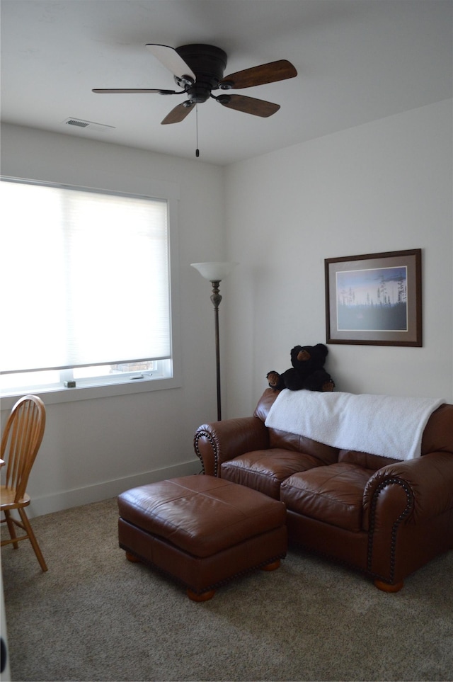 carpeted living area featuring ceiling fan and baseboards